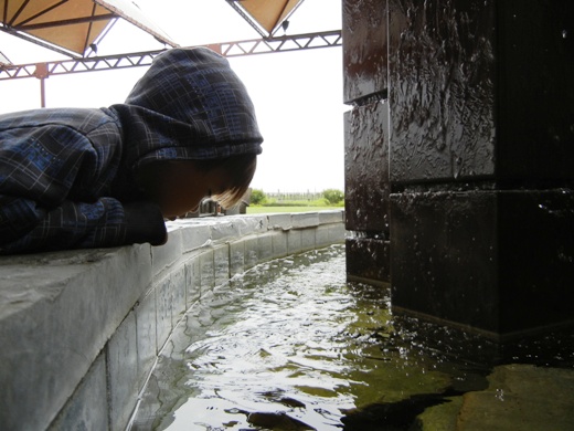 Checking out the fountain extremely closely.