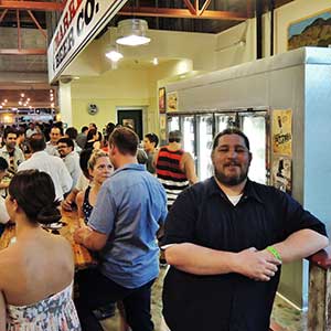 BOTTLED UP - Jake McCluskey, general manager of the Market Beer Co. at San Pedro Square Market, says that the shop stocks larger bottles of craft beer to encourage customers to share
